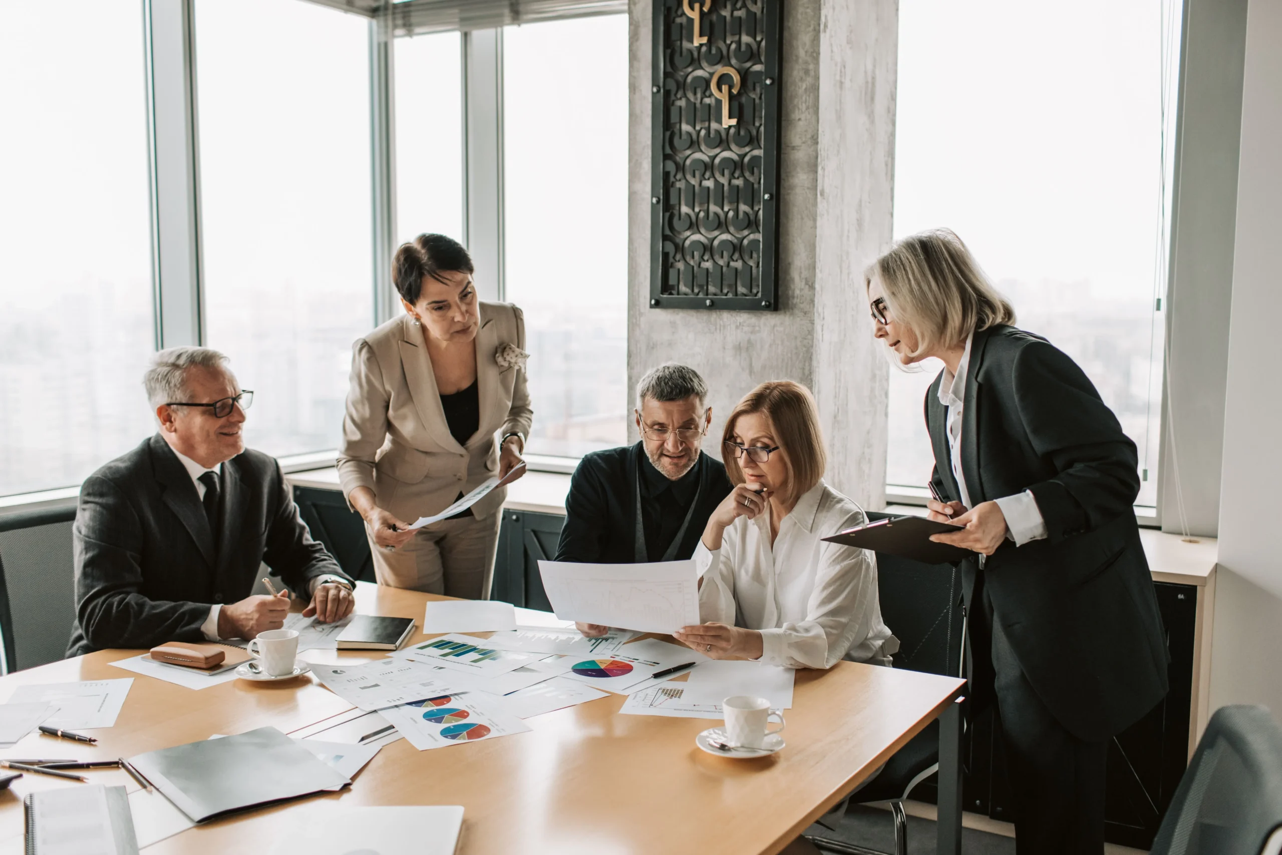 Professionisti durante una riunione aziendale per l'analisi di documenti e la pianificazione finanziaria.